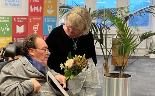Magnus Andén tar emot diplom och blommor med stöd av god man Gerd Andén