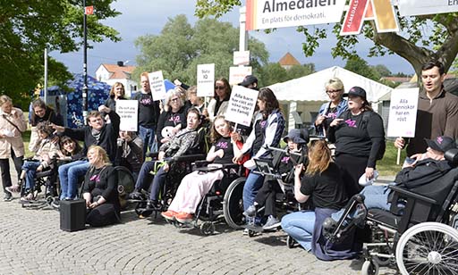 Personer i en manifestation, bär plakat.
