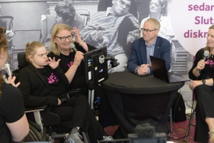 Fyra personer i ett panelsamtal. En av dem är en ung rullstolsburen kvinna. En person står med ryggen mot kameran.