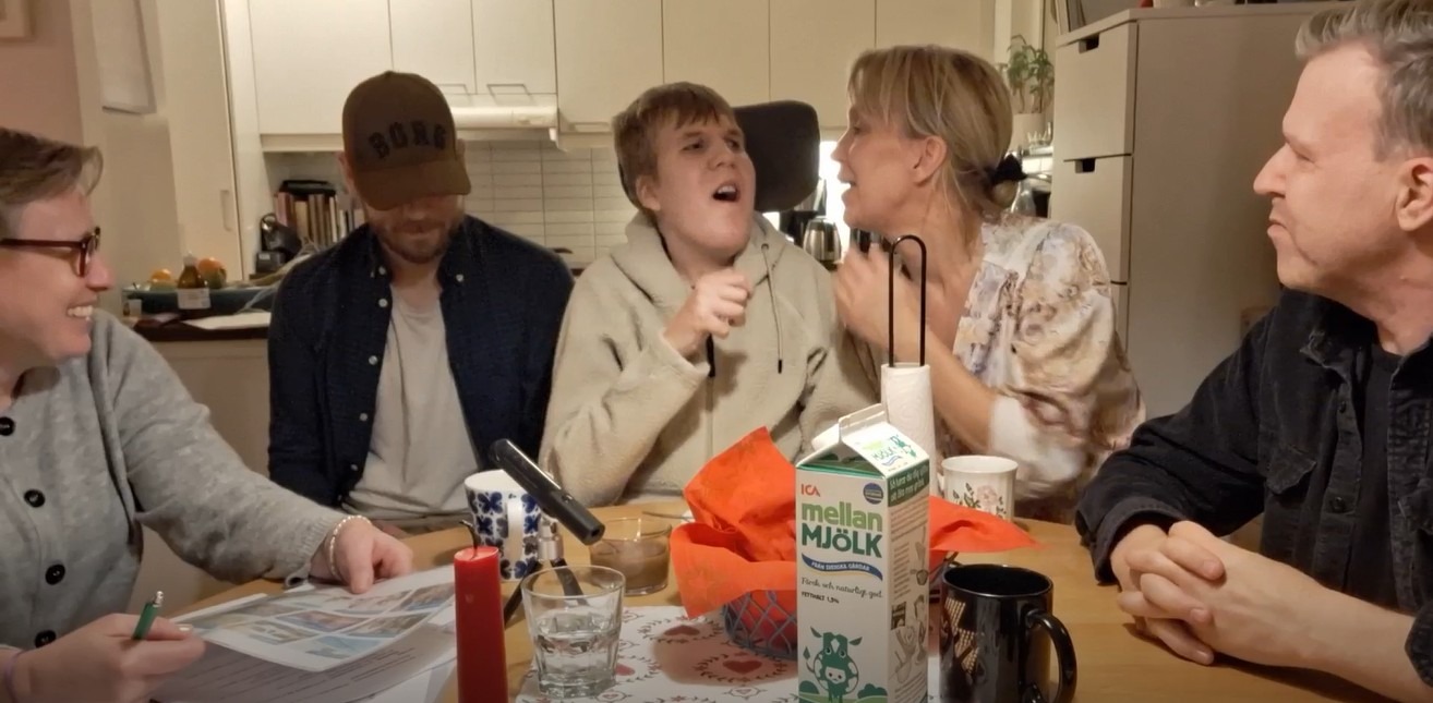 Glada personer runt ett köksbord
